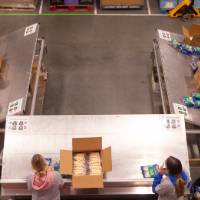 Birds eye view of students loading assorted food into boxes
